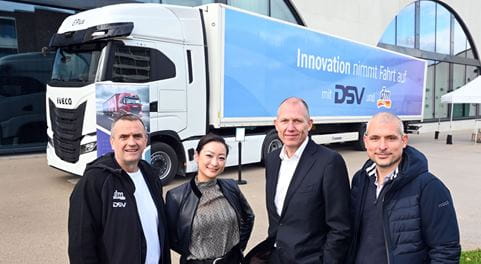vier Personen vor einem Lkw