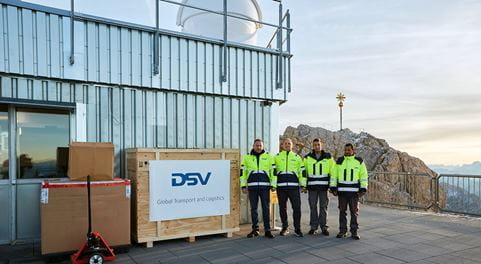 DSV-Mitarbeiter neben Transportkiste