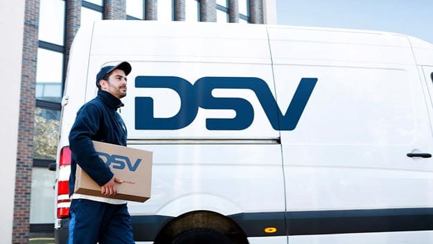 A DSV employee standing next to an DSV truck, ready to make a same-day delivery.