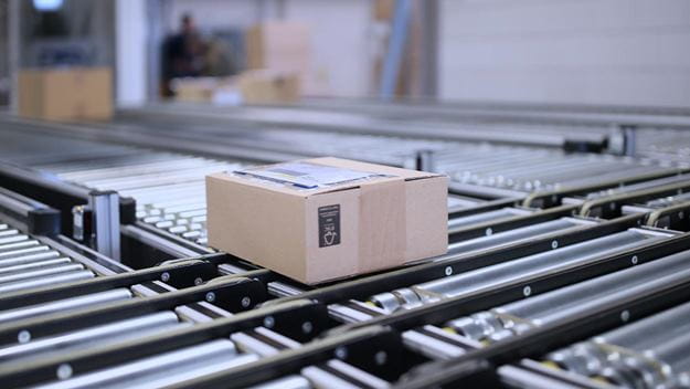 A cardboard box moves along a conveyor belt in a DSV warehouse.