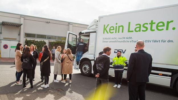 Personne vor einem E-Lkw