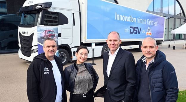 Vier Personen vor einem Lkw