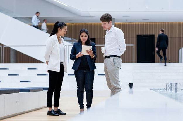 Drei junge Menschen schauen auf ein  Dokument