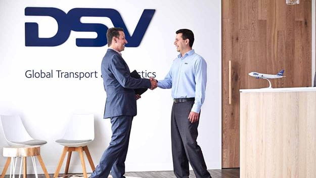 To mandlige DSV-medarbejdere giver hånd på et DSV-sted