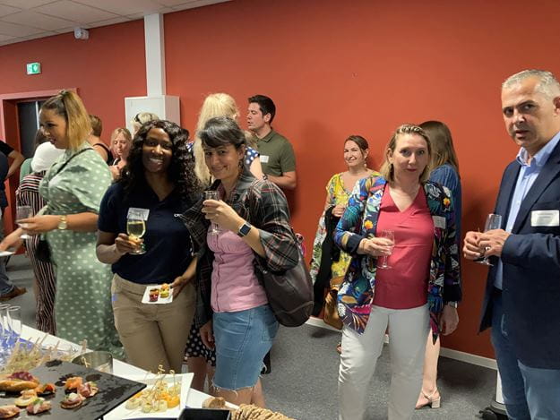 groupe de personnes qui mangent, sourient et discutent