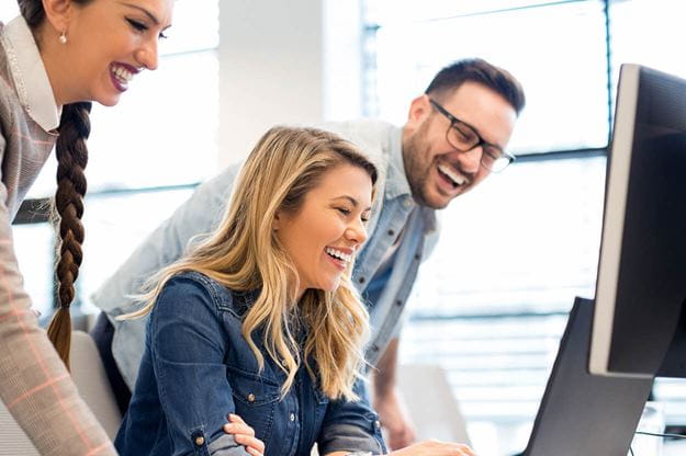 Two DSV employees a man and a woman looking at a computer screen in an office