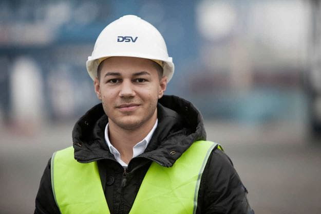 DSV 员工在港口一名戴着头盔和黄色安全夹克的男子