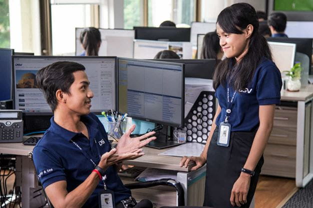 Two DSV employees a man and a woman in a discussion in the office