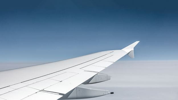 Airplane wing with blue sky background