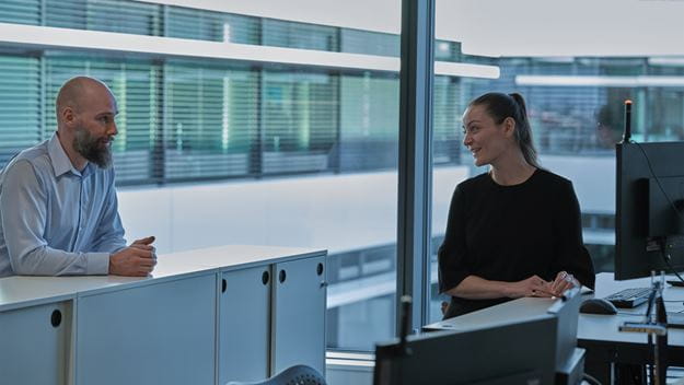 Two DSV employees in conversation in the office