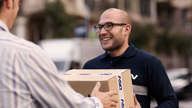 A DSV male employee with glasses delivering a parcel to a customer