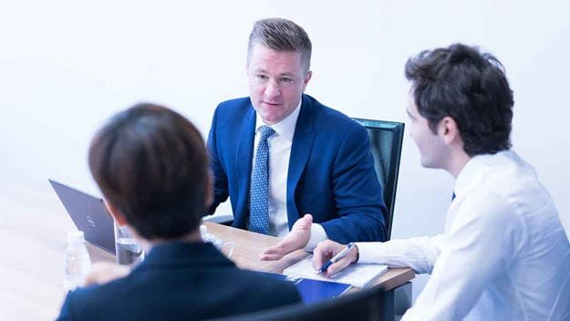 tre anställda som diskuterar i soffa