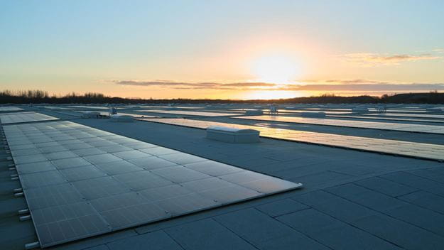 Paneles solares en un techo con un cielo azul de fondo