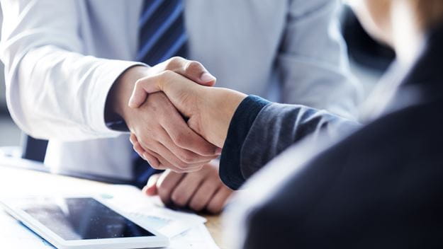 Zwei Menschen geben sich die Hand