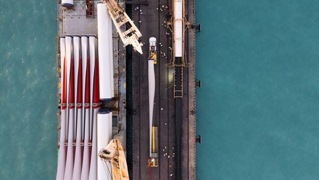 Rotor blades of a wind turbine moved from a ship to a bridge