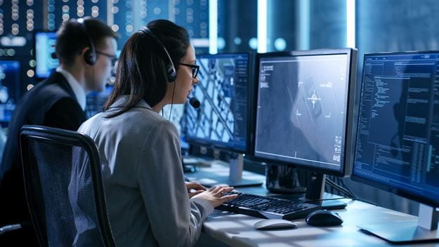 A woman and a man working at laptops looking into the screen.