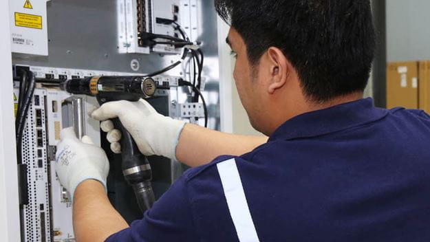 Técnico de almacén perforando e instalando