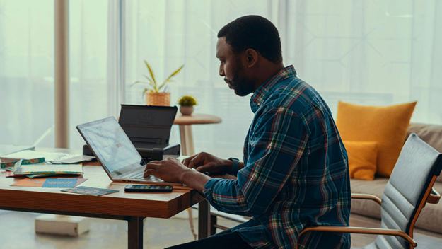 A man sitting at a table with his laptop