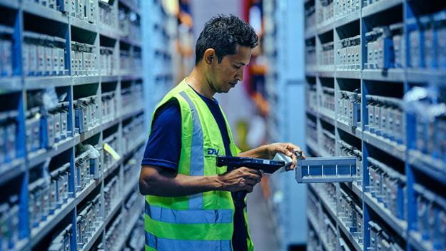 Warehouse worker at picking area with barcode scanner