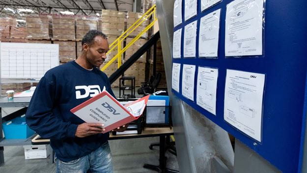 Warehouse worker checking documents inside warehouse