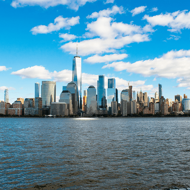 Daytime view of the New York City skyline from across the water, featuring iconic skyscrapers such as the One World Trade Center