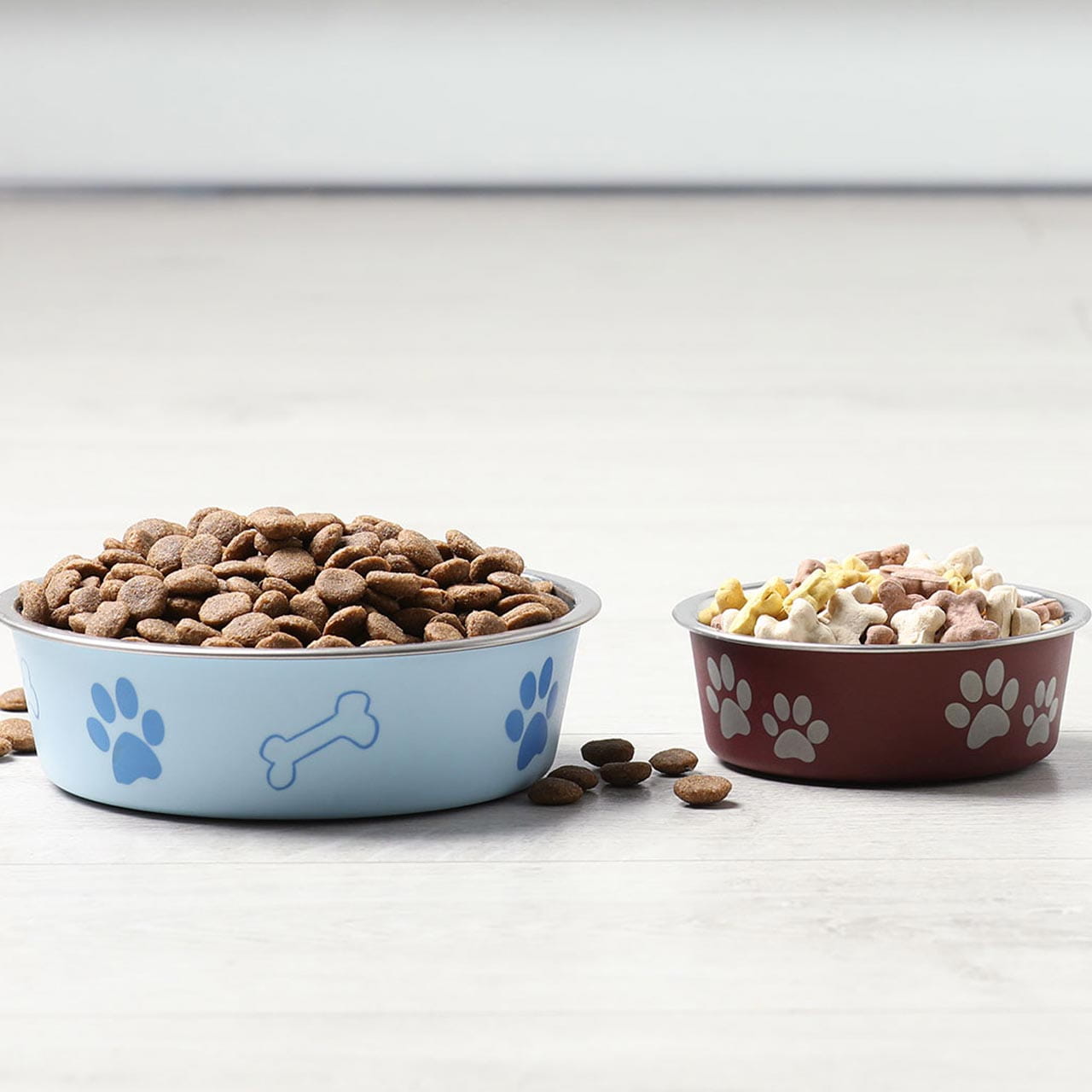 Two pet bowls placed on a clean, light-coloured wooden floor