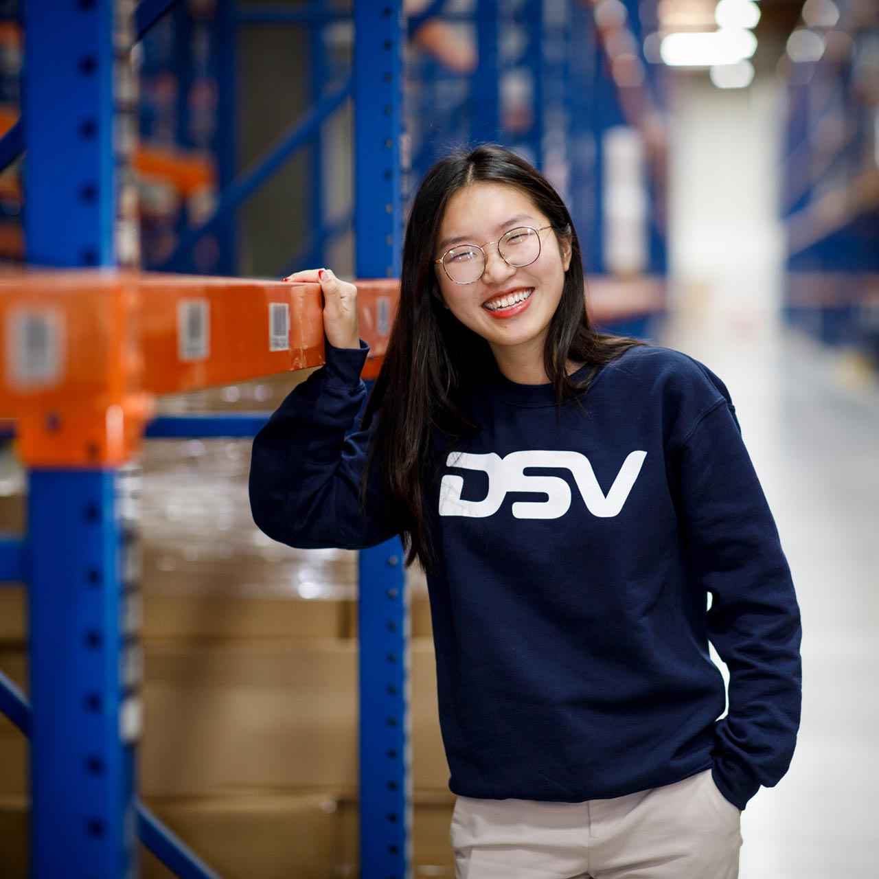 Asian woman in warehouse with DSV sweatshirt